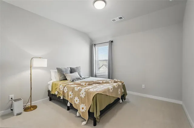 a bed sitting in a bedroom next to a window