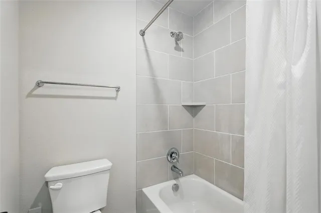 a bath room with a toilet and a bath tub