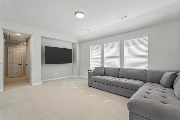 a living room with furniture windows and a flat screen tv