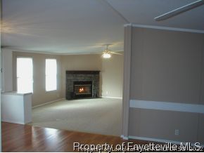 8267 Godwin-Falcon Road Godwin, NC 28344 - Photo 3 of 10 a view of empty room with fireplace and wooden floor