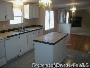 8267 Godwin-Falcon Road Godwin, NC 28344 - Photo 7 of 10 a kitchen with granite countertop a sink a stove and cabinets