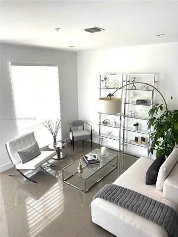 a living room with furniture and floor to ceiling window