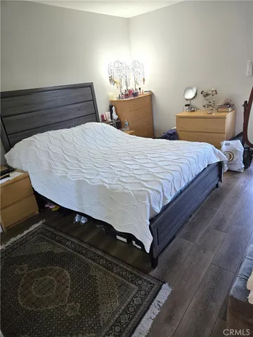 a bedroom with a bed and a lamp on dresser