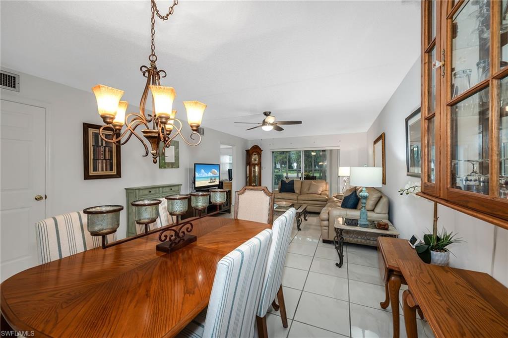200 Valley Stream Drive, Unit 3B Naples, FL 34113 - Photo 11 of 45 a view of a dining room with furniture wooden floor and chandelier