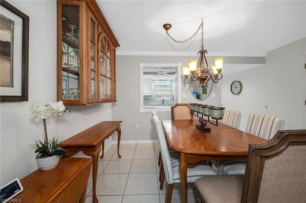 200 Valley Stream Drive, Unit 3B Naples, FL 34113 - Photo 13 of 45 a view of a dining room with furniture and chandelier