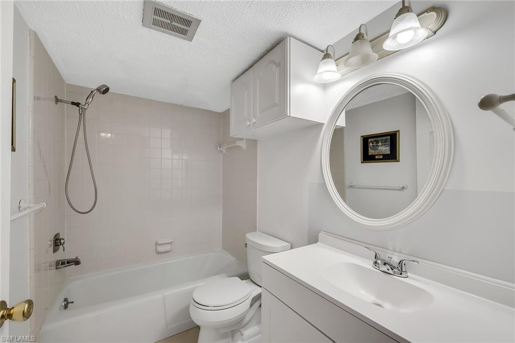 200 Valley Stream Drive, Unit 3B Naples, FL 34113 - Photo 22 of 45 a bathroom with a sink a toilet and a mirror