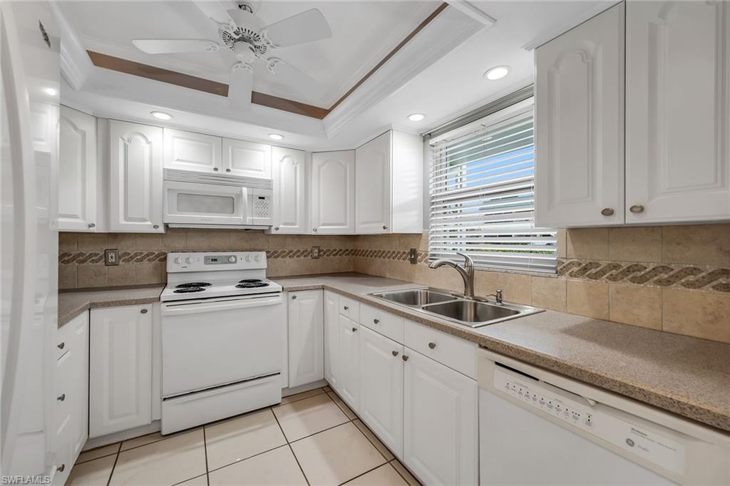 200 Valley Stream Drive, Unit 3B Naples, FL 34113 - Photo 3 of 45 a kitchen with kitchen island granite countertop white cabinets white stainless steel appliances with a sink and dishwasher