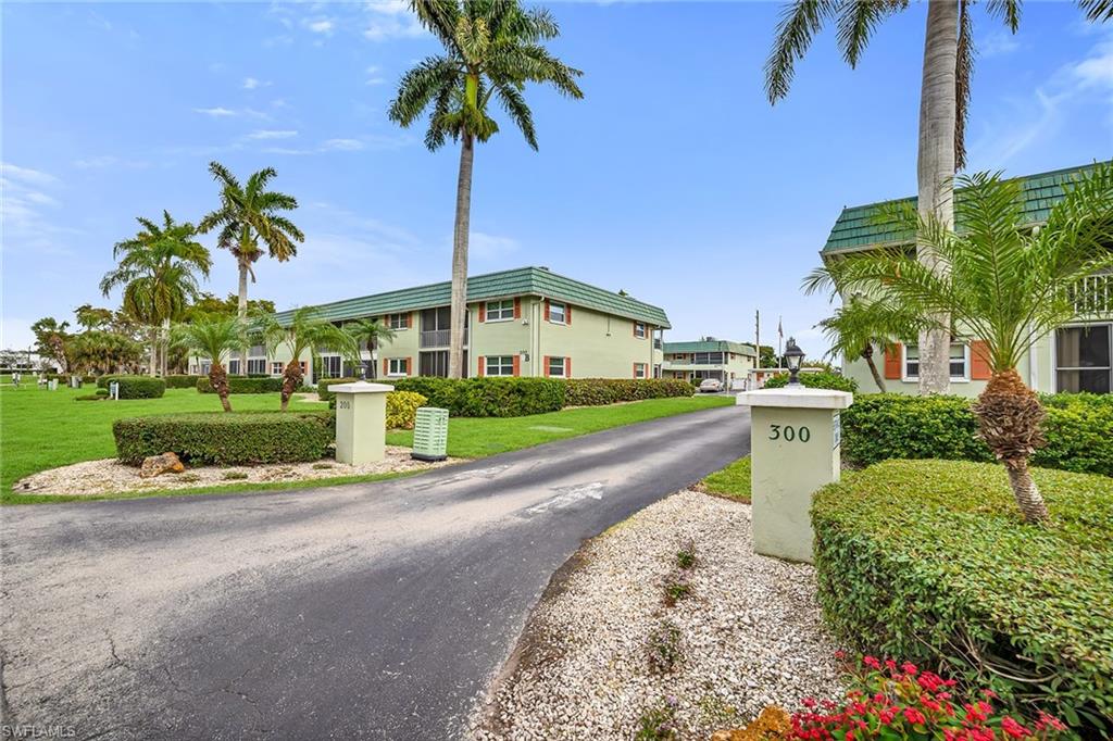 200 Valley Stream Drive, Unit 3B Naples, FL 34113 - Photo 32 of 45 a front view of a house with a garden and lake view