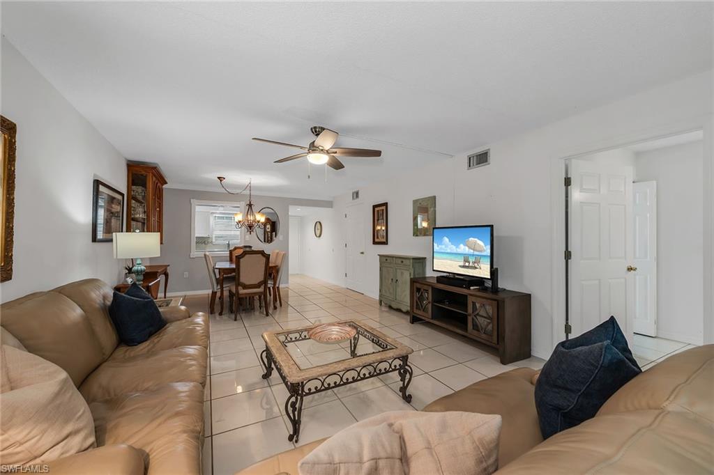 200 Valley Stream Drive, Unit 3B Naples, FL 34113 - Photo 6 of 45 a living room with furniture a fireplace and a flat screen tv