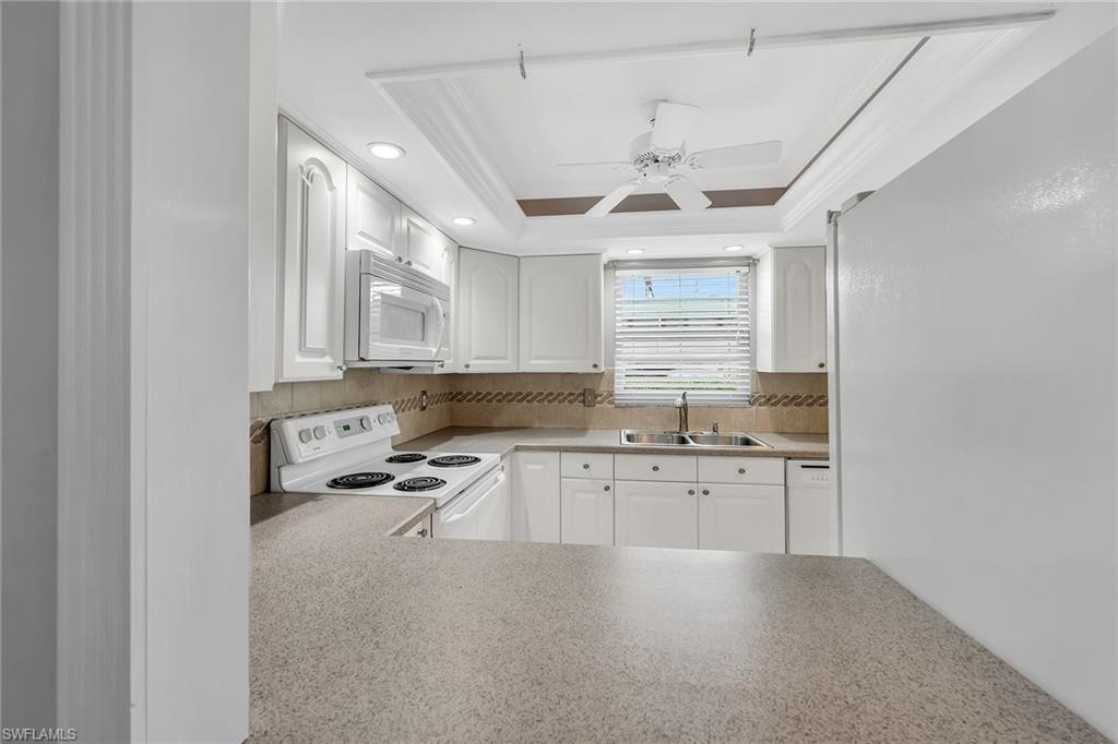 200 Valley Stream Drive, Unit 3B Naples, FL 34113 - Photo 9 of 45 a kitchen with granite countertop a sink stainless steel appliances and cabinets