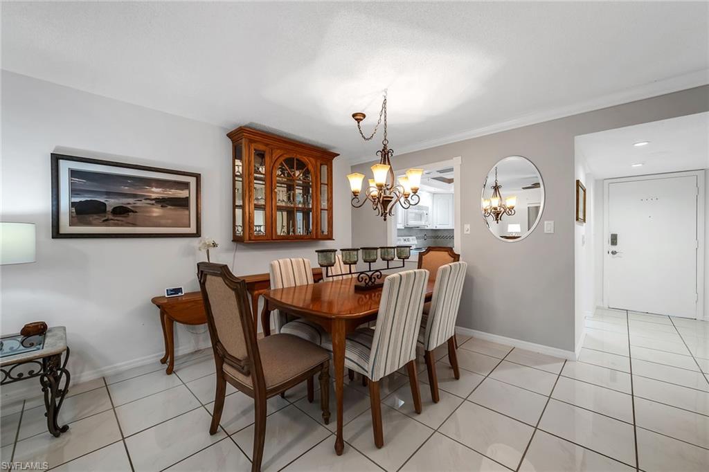 200 Valley Stream Drive, Unit 3B Naples, FL 34113 - Photo 10 of 45 a dining room with furniture and chandelier