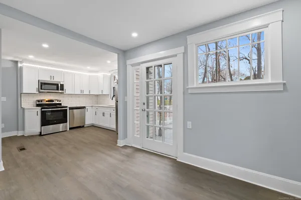 a view of kitchen with wooden floor and electronic appliances