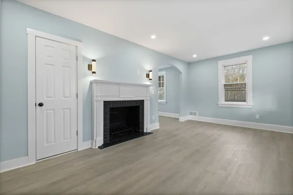 an empty room with windows and a fireplace