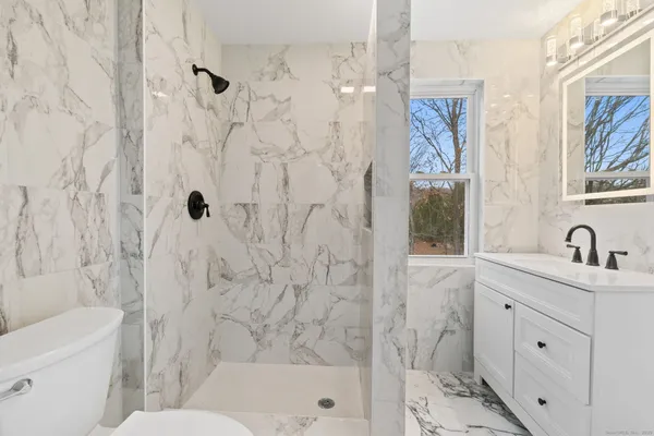 a bathroom with a granite countertop sink toilet and shower