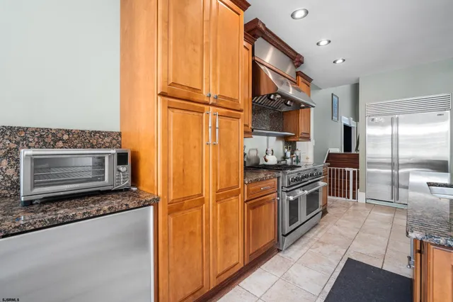 a kitchen with stainless steel appliances granite countertop a granite counter tops and a refrigerator