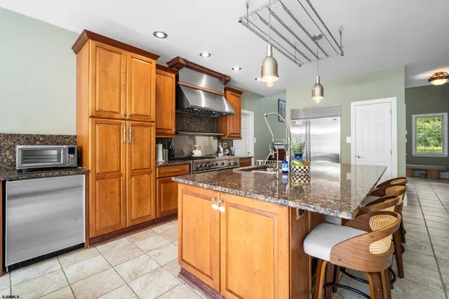 a kitchen with stainless steel appliances granite countertop a refrigerator and a stove top oven