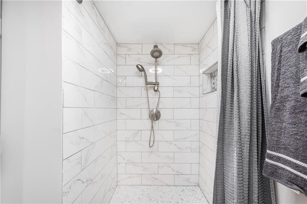 1015 Greentree Road Pittsburgh, PA 15220 - Photo 21 of 25 The Lower Level Also Features a Full Bath with a Pocket Door and Oversized Walk-In Shower with Custom Tile Surround