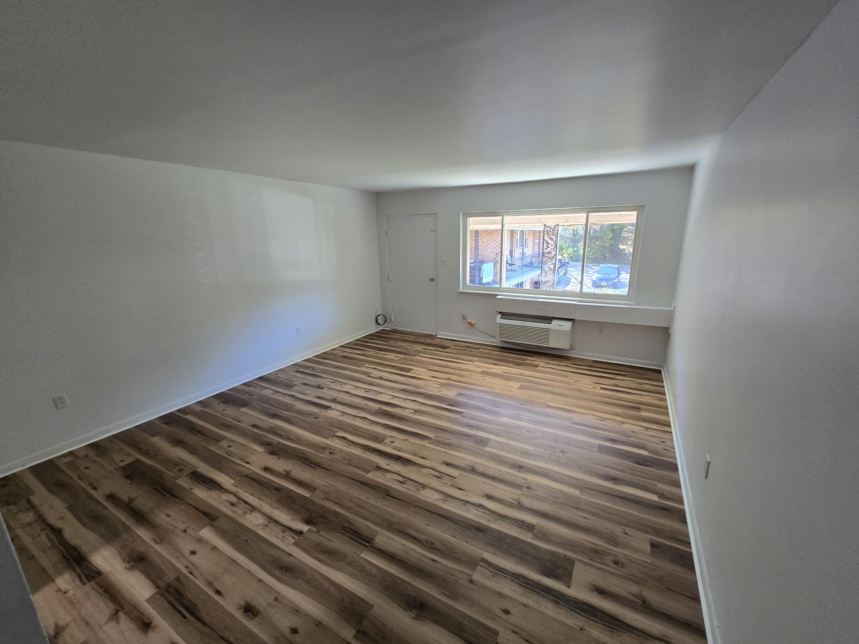 2607 Westover Avenue Southwest, Unit 207 Roanoke, VA 24015 - Photo 2 of 7 a view of an empty room with wooden floor and a window