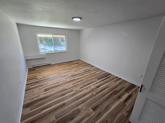 a view of an empty room and wooden floor