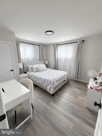 a bedroom with two beds and wooden floor