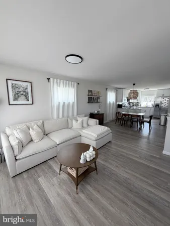 a living room with furniture wooden floor and dining table