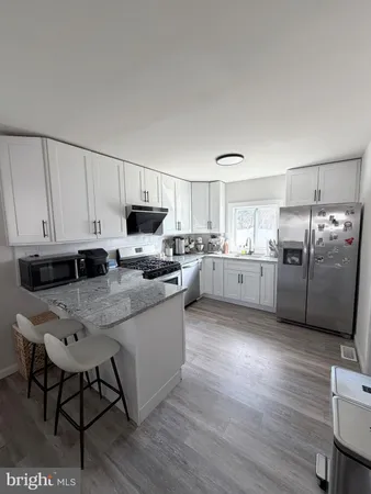 a kitchen with stainless steel appliances granite countertop a refrigerator a stove top oven a sink and dishwasher