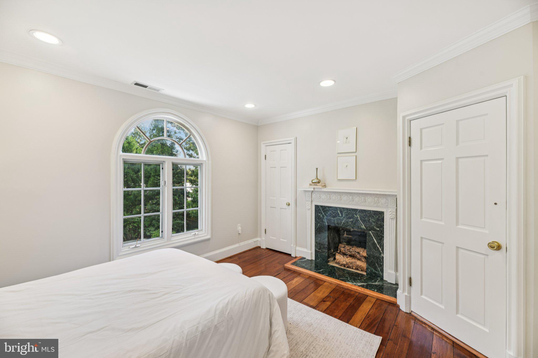 1545 35th Street Northwest Washington, DC 20007 - Photo 41 of 65 a bedroom with a bed and a fireplace