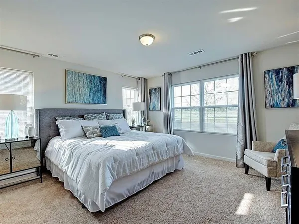 a bedroom with a bed and large window