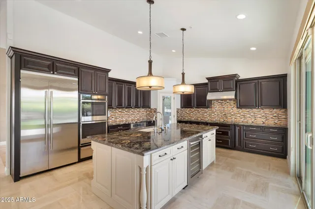 a kitchen with stainless steel appliances granite countertop a stove a sink and a refrigerator