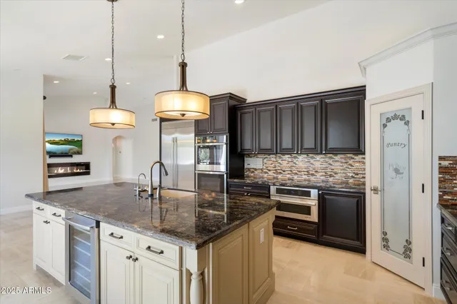 a kitchen with stainless steel appliances granite countertop a stove a sink and a refrigerator