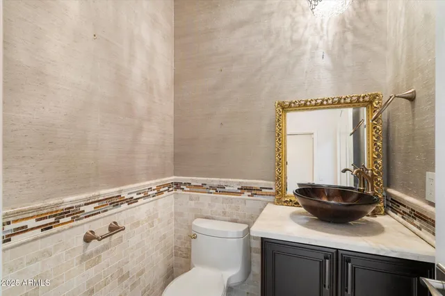 a bathroom with a granite countertop sink a toilet a vanity and mirror