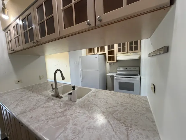 a kitchen with stainless steel appliances granite countertop a refrigerator a stove and a sink