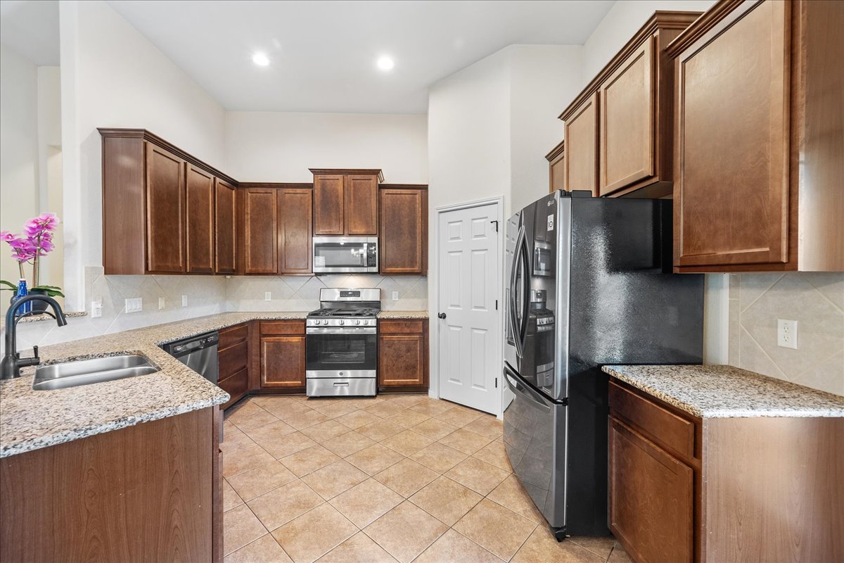 3000 Rio Verde Drive Leander, TX 78641 - Photo 8 of 23 a kitchen with stainless steel appliances granite countertop a refrigerator stove and sink