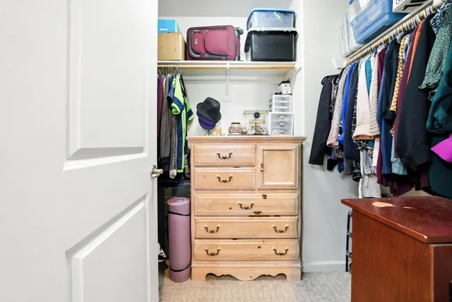 a view of walk in closet with clothes and shoes