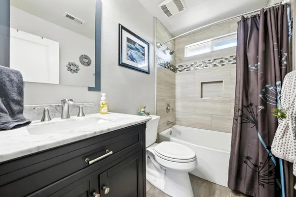 a bathroom with a granite countertop sink toilet and shower