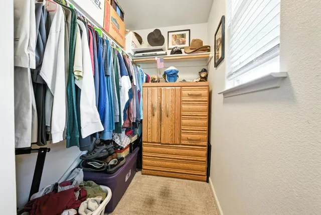 a view of walk in closet with clothes and shoes