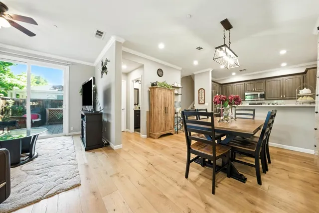 a view of a dining room and livingroom with furniture wooden floor a chandelier
