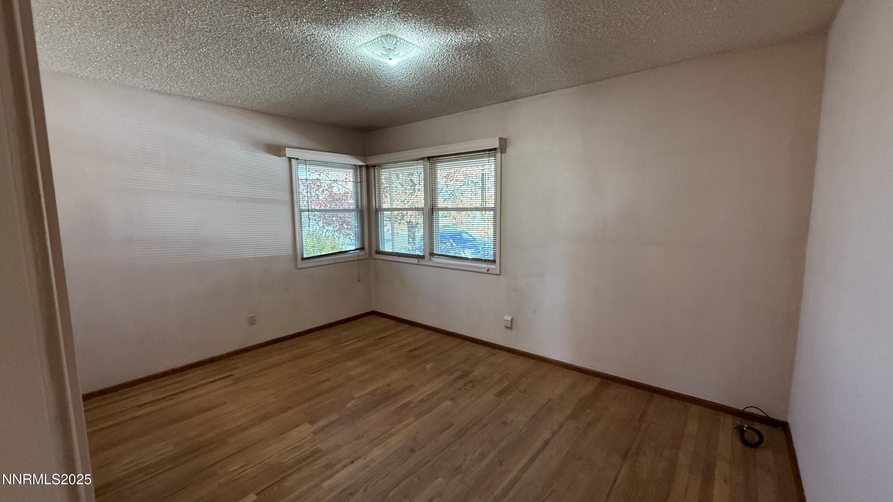 1455 Wesley Drive Reno, NV 89503 - Photo 14 of 27 an empty room with wooden floor and windows