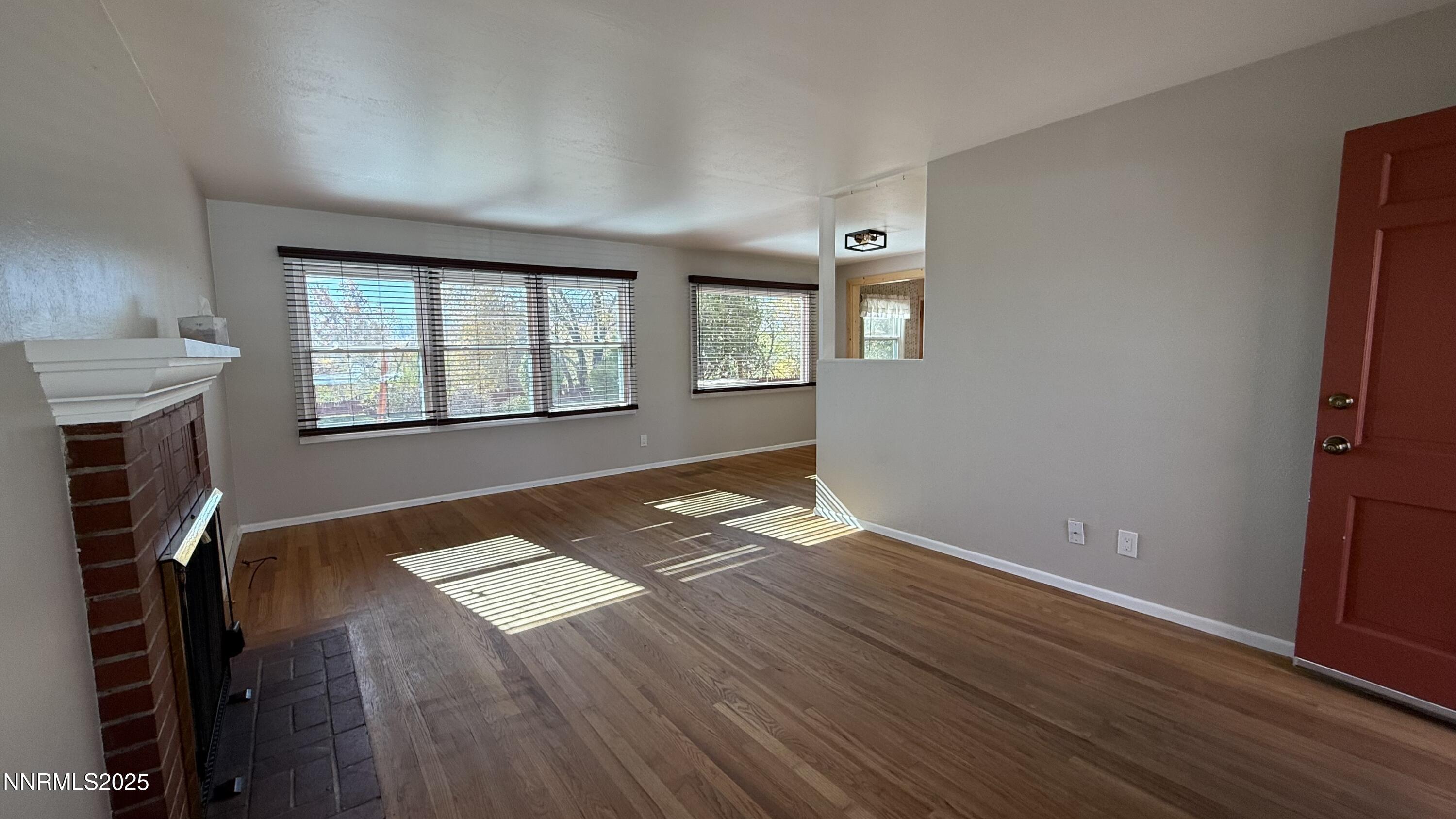 1455 Wesley Drive Reno, NV 89503 - Photo 4 of 27 an empty room with wooden floor and windows