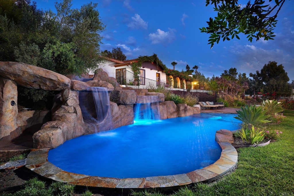3182 Lone Jack Road Encinitas, CA 92024 - Photo 2 of 37 a view of a swimming pool with lawn chairs under an umbrella