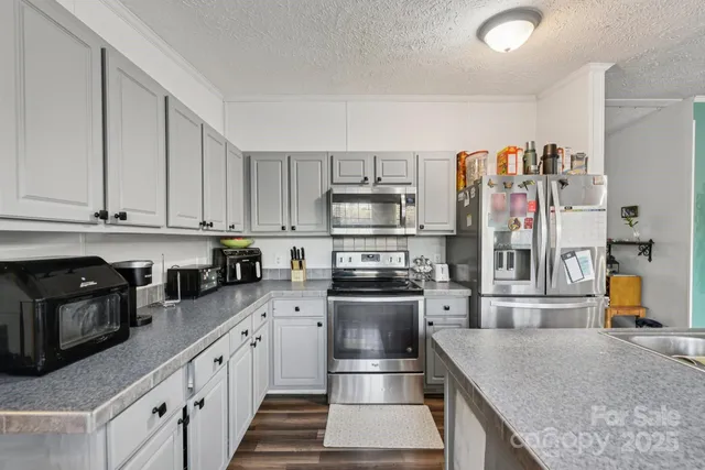 a kitchen with stainless steel appliances granite countertop a refrigerator and stove