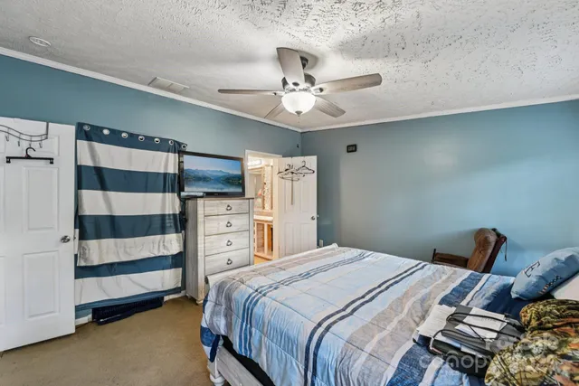 a bedroom with a bed and a ceiling fan