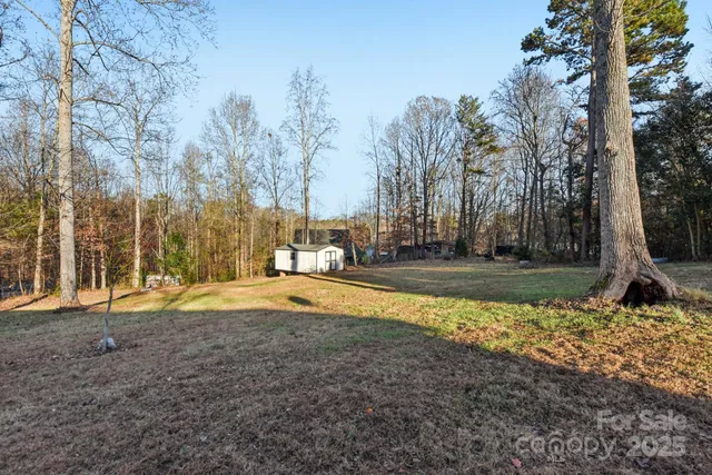 a view of yard with swimming pool and trees