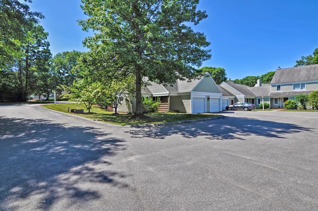 125 Stone Ridge Road, Unit 125 Franklin, MA 02038 - Photo 3 of 24 a front view of a house with a yard and garage