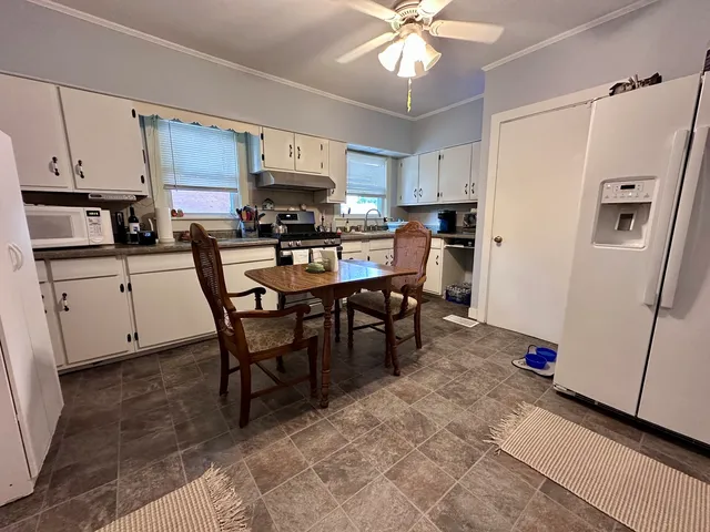 a view of kitchen with cabinets stainless steel appliances and a dining table