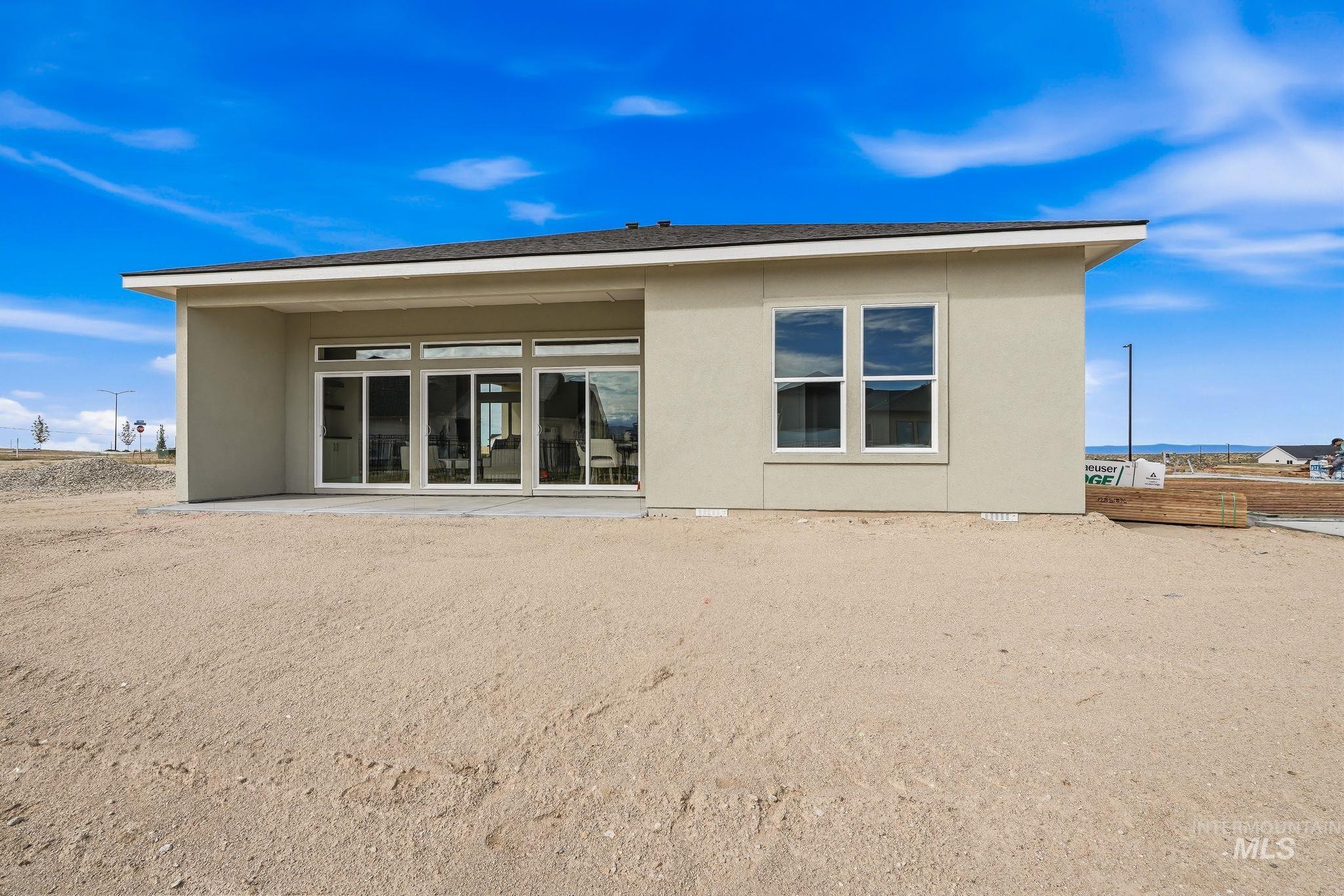 470 South Radiator Way Boise, ID 83716 - Photo 49 of 50 Rear exterior featuring a large covered patio with sliding glass doors, a single fixed window, and neutral stucco siding