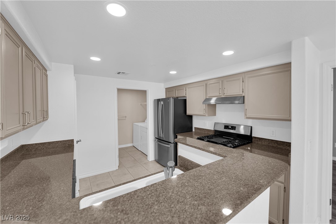 10550 West Alexander Road, Unit 2079 Las Vegas, NV 89129 - Photo 7 of 40 Kitchen featuring separate washer and dryer, appliances with stainless steel finishes, under cabinet range hood, recessed lighting, and dark stone countertops