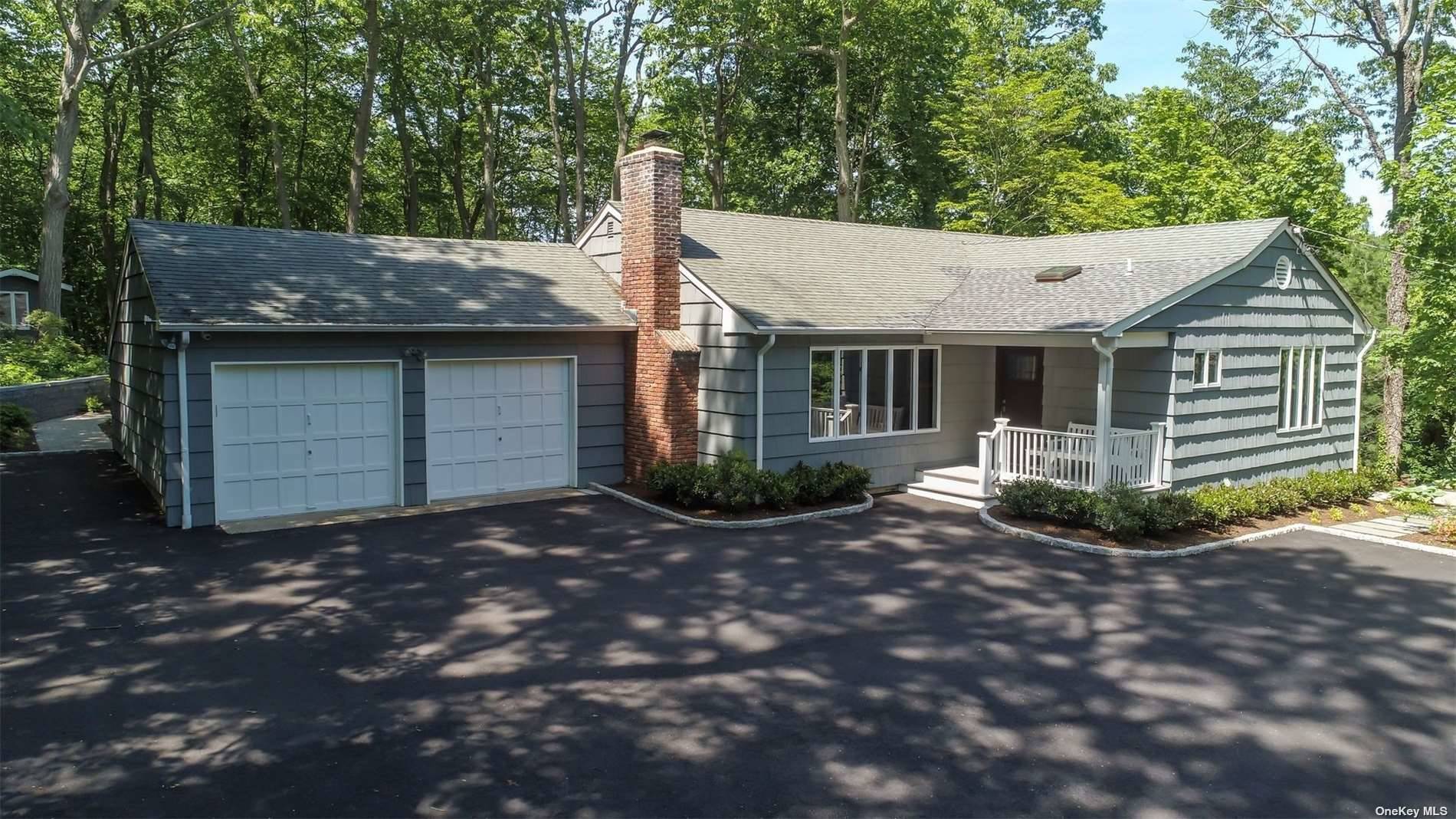 a view of a house with a small yard plants and large tree