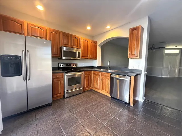 a kitchen with stainless steel appliances granite countertop a stove a sink and a refrigerator