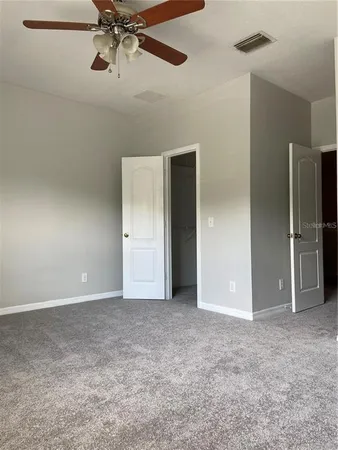 a view of an empty room and a fan
